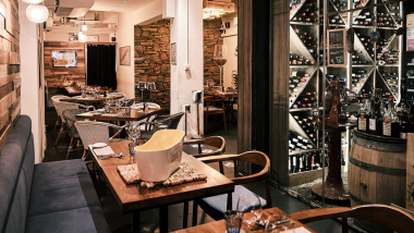 Dining tables and wine bottles at Gaston Burgundy bistro and wine bar in Singapore.