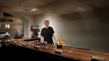 Chef standing behind kitchen counter at Dashi Japanese restaurant in Stockholm, Sweden.