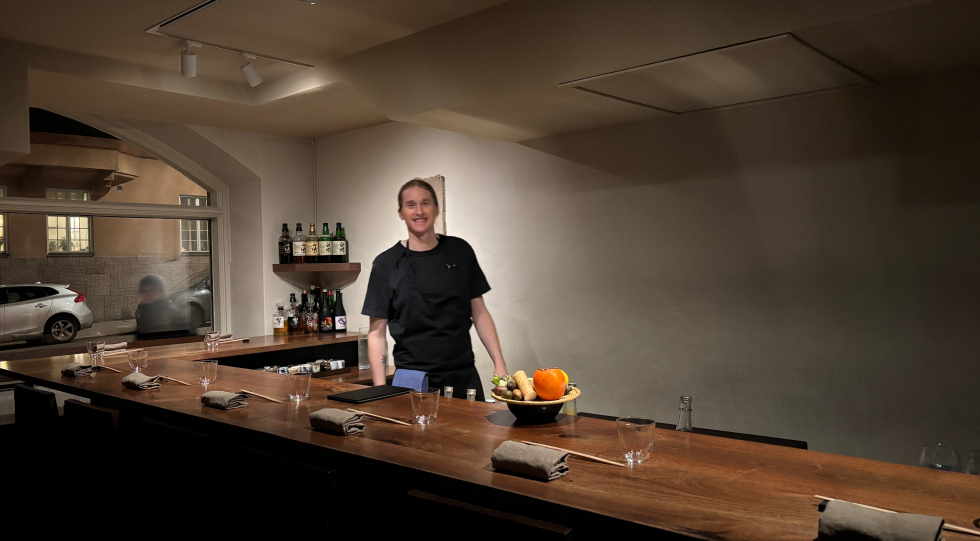 Chef standing behind kitchen counter at Dashi Japanese restaurant in Stockholm, Sweden.